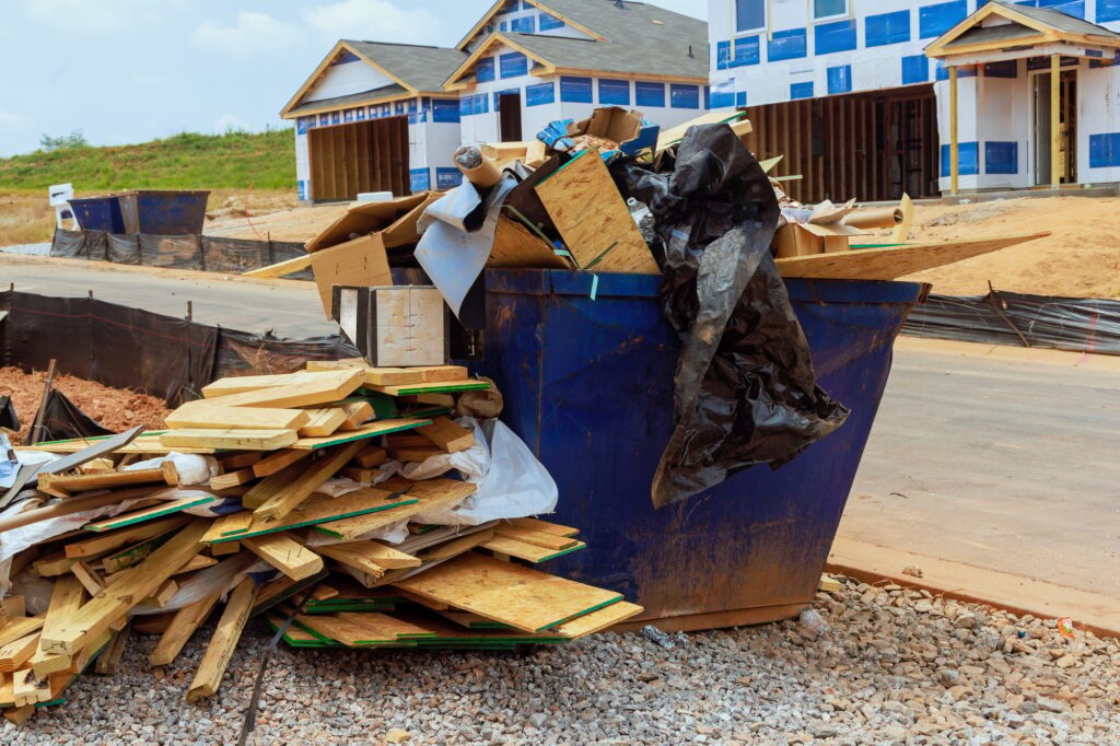 When house is being constructed, a metal garbage container is used to dispose of construction waste
